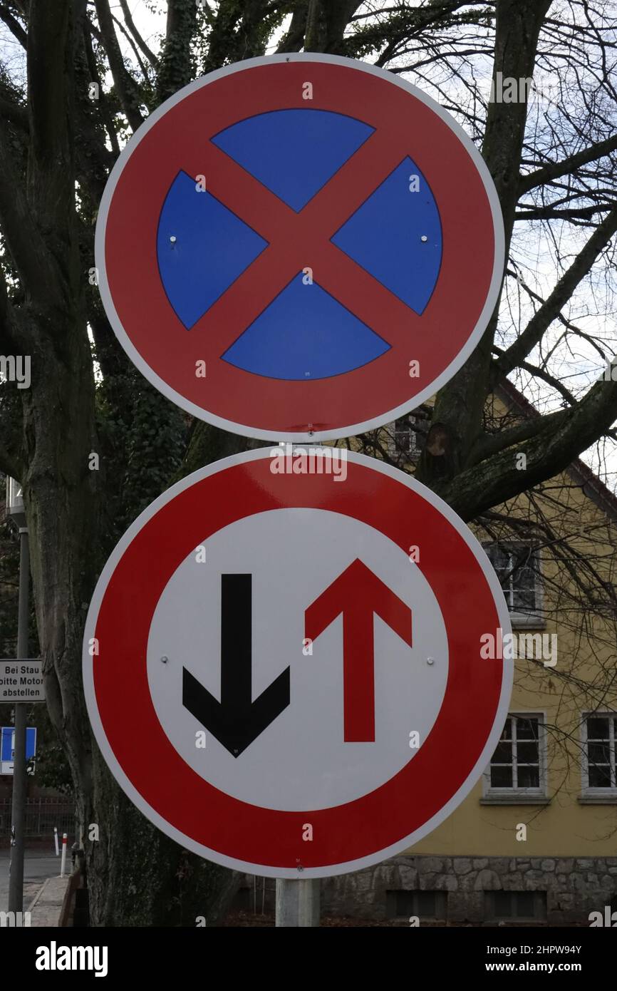 Red and blue German traffic sign 283 'No stopping' on top of red, white and black German traffic sign 208 'Priority for oncoming traffic' Stock Photo