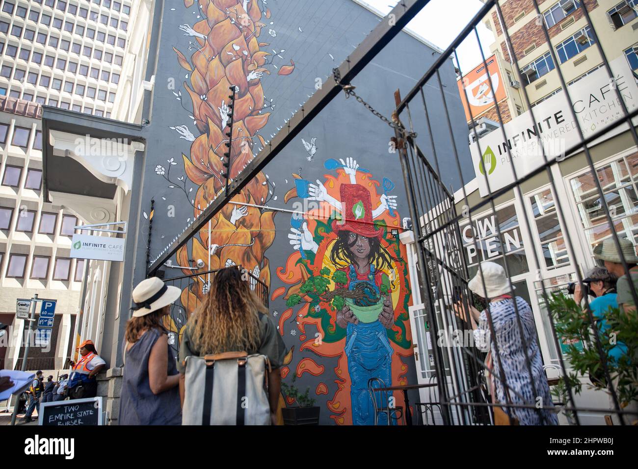 Cape Town, South Africa. 23rd Feb, 2022. Tourists view a mural during the International Public Arts Festival in Cape Town, South Africa, on Feb. 23, 2022. The sixth edition of the International Public Arts Festival, Africa's largest street art festival, is held from Wednesday to Sunday in Cape Town, with new large murals to beautify walls in the central business district. Credit: Lyu Tianran/Xinhua/Alamy Live News Stock Photo