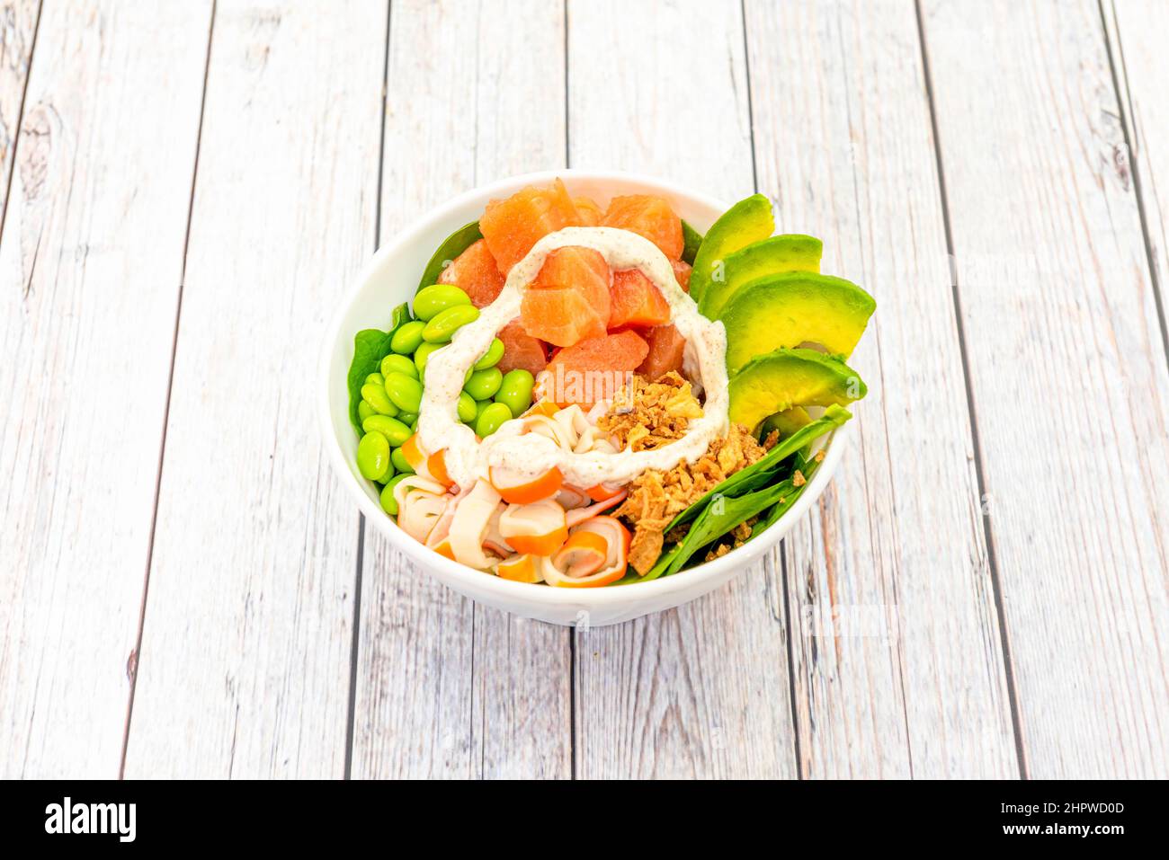 Diced salmon bowl with avocado slices, edamame beans, surimi slices