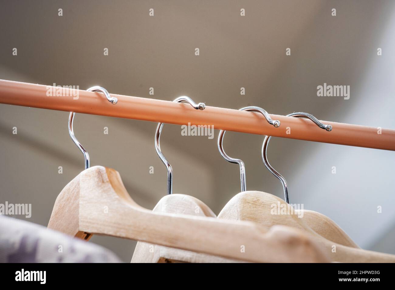 Wooden hangers hanging on a light brown bar or tile Stock Photo