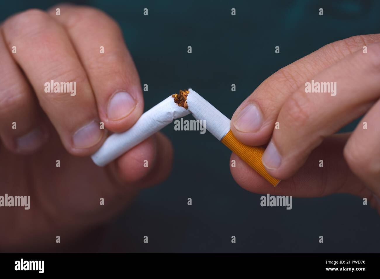 Stop smoking, quit smoking or no smoking cigarettes. Man holding broken