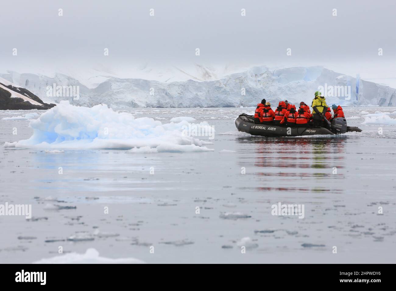 Cruise passengers from Le Boreal cruise ship traversing the ice strewn waters of Paradise Bay in a zodiac boat, just east of Bryde Island, Antarctica. Stock Photo