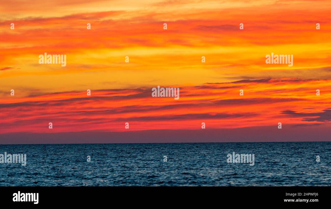 vibrant orange sunset sky and clouds over ocean Stock Photo - Alamy
