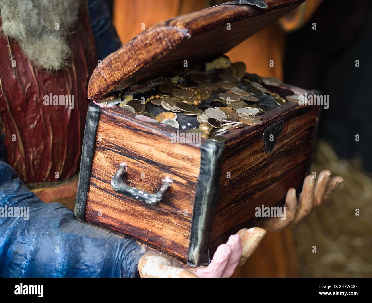 Hands Holding Wooden Treasure Chest with Coins Stock Photo