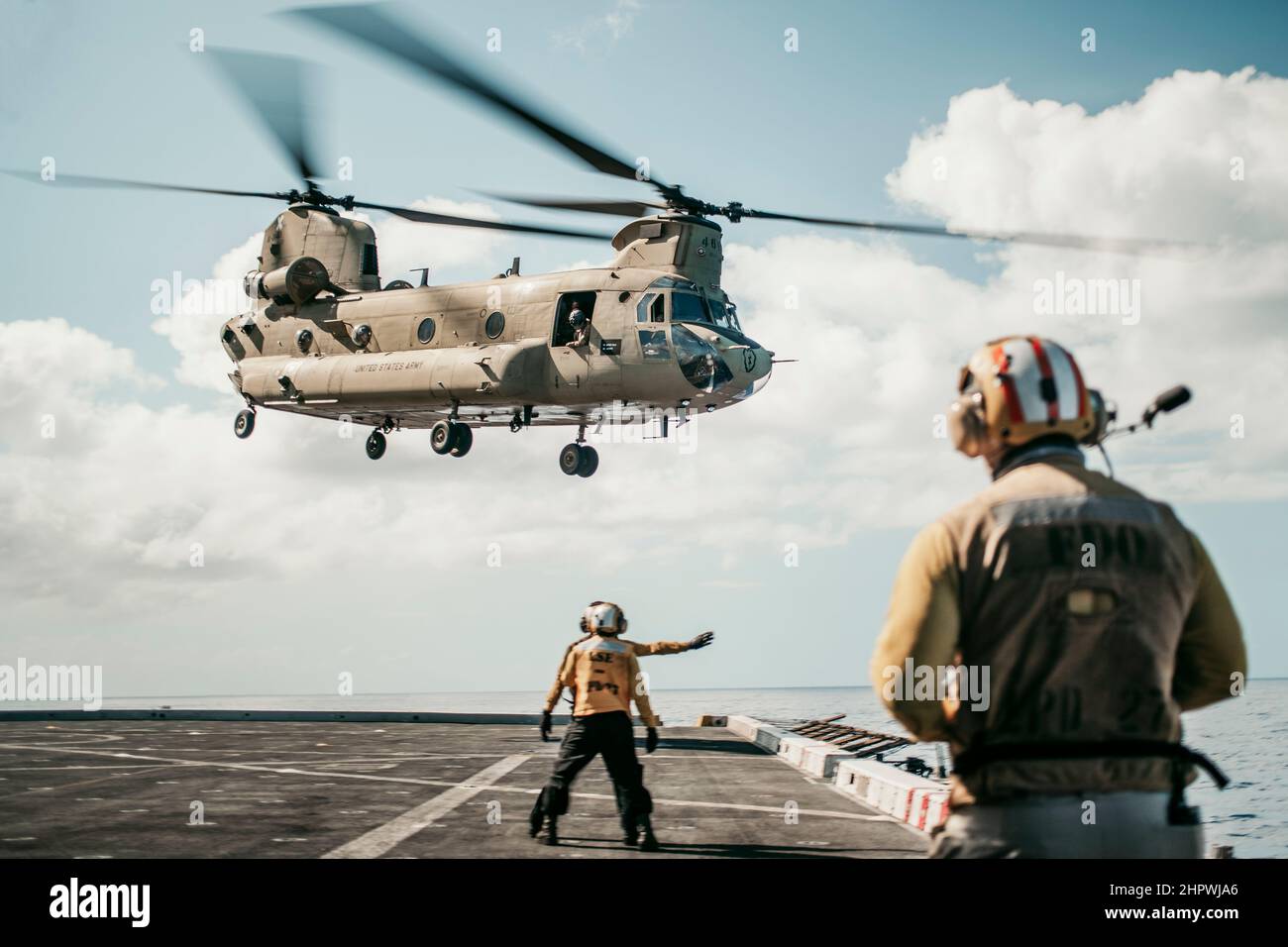 PACIFIC OCEAN (Feb. 18, 2022) U.S. Sailors assigned to amphibious transport dock USS Portland (LPD 27) signal to a U.S. Army CH-47F Chinook attached to 3rd Battalion, 25th Aviation Regiment, 25th Combat Aviation Brigade, while conducting deck landing qualifications, Feb. 18. Marines and Sailors of the 11th Marine Expeditionary Unit and Essex Amphibious Ready Group are underway conducting routine operations in U.S. 3rd Fleet. (U.S. Marine Corps photo by Gunnery Sgt. Donald Holbert) Stock Photo