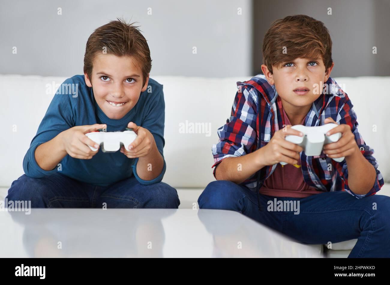 Im gonna beat you. Shot of two young boys concentrating while playing video games. Stock Photo