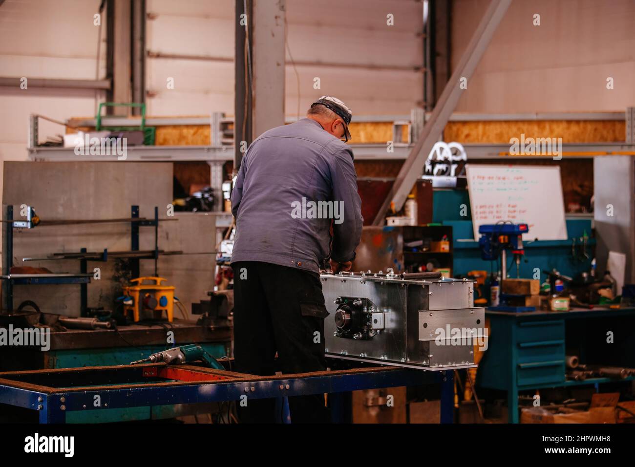 Factory workers assembling industrial equipment in workshop Stock Photo ...