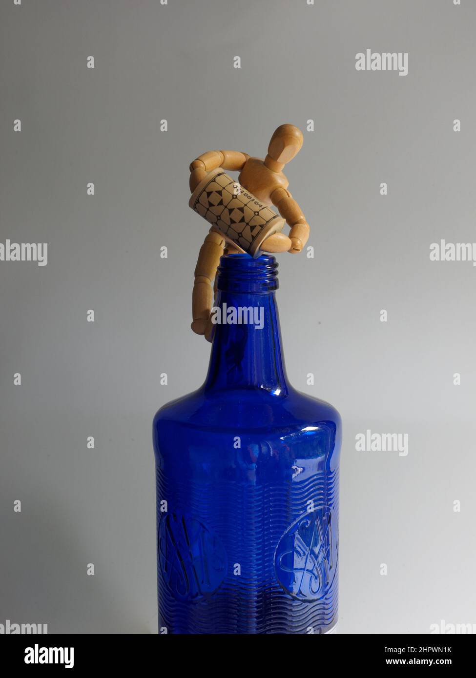 Still life, symbol photo work, wooden figure with blue bottle and cork, Germany Stock Photo