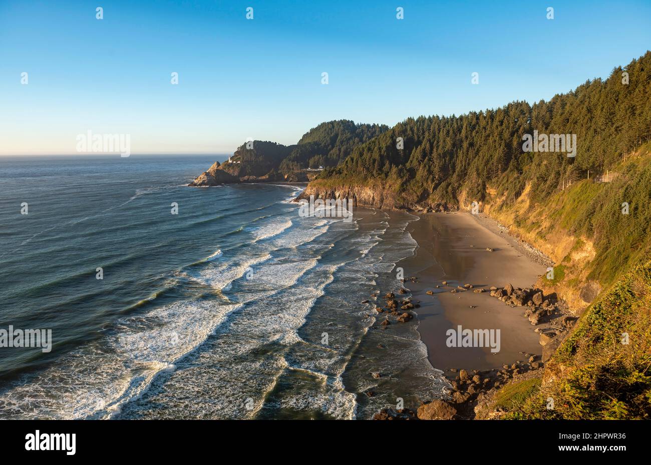 Sandy beach Sealion Beach with Devils Elbow, in the back rocky coast with Heceta Head lighthouse, Oregon, USA Stock Photo