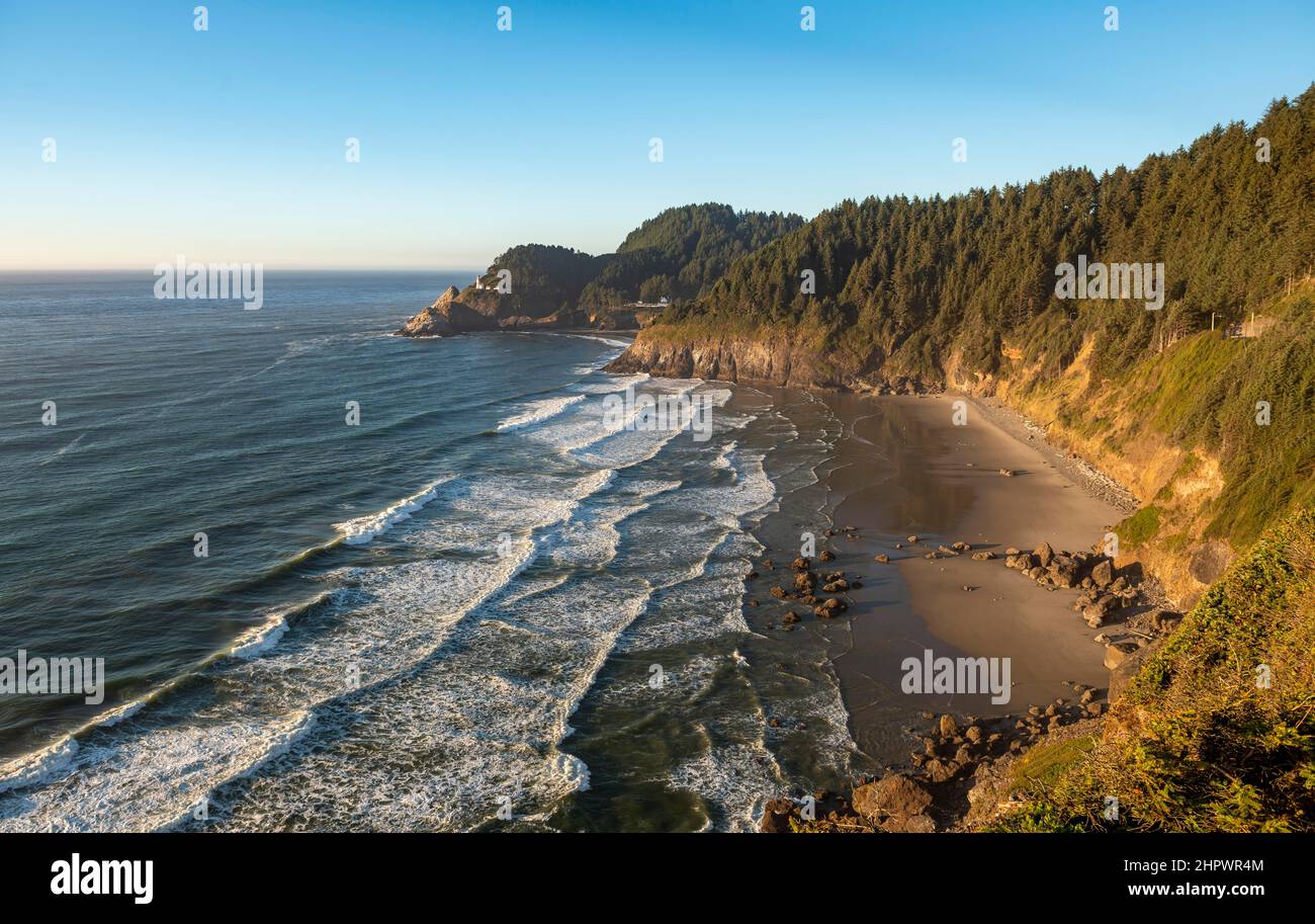 Sandy beach Sealion Beach with Devils Elbow, in the back rocky coast with Heceta Head lighthouse, Oregon, USA Stock Photo