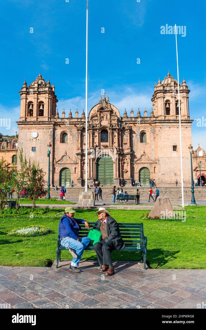 Two men talking on a bench in front of the Cusco Cathedral, Plaza de Armas, Cusco, Peru Stock Photo