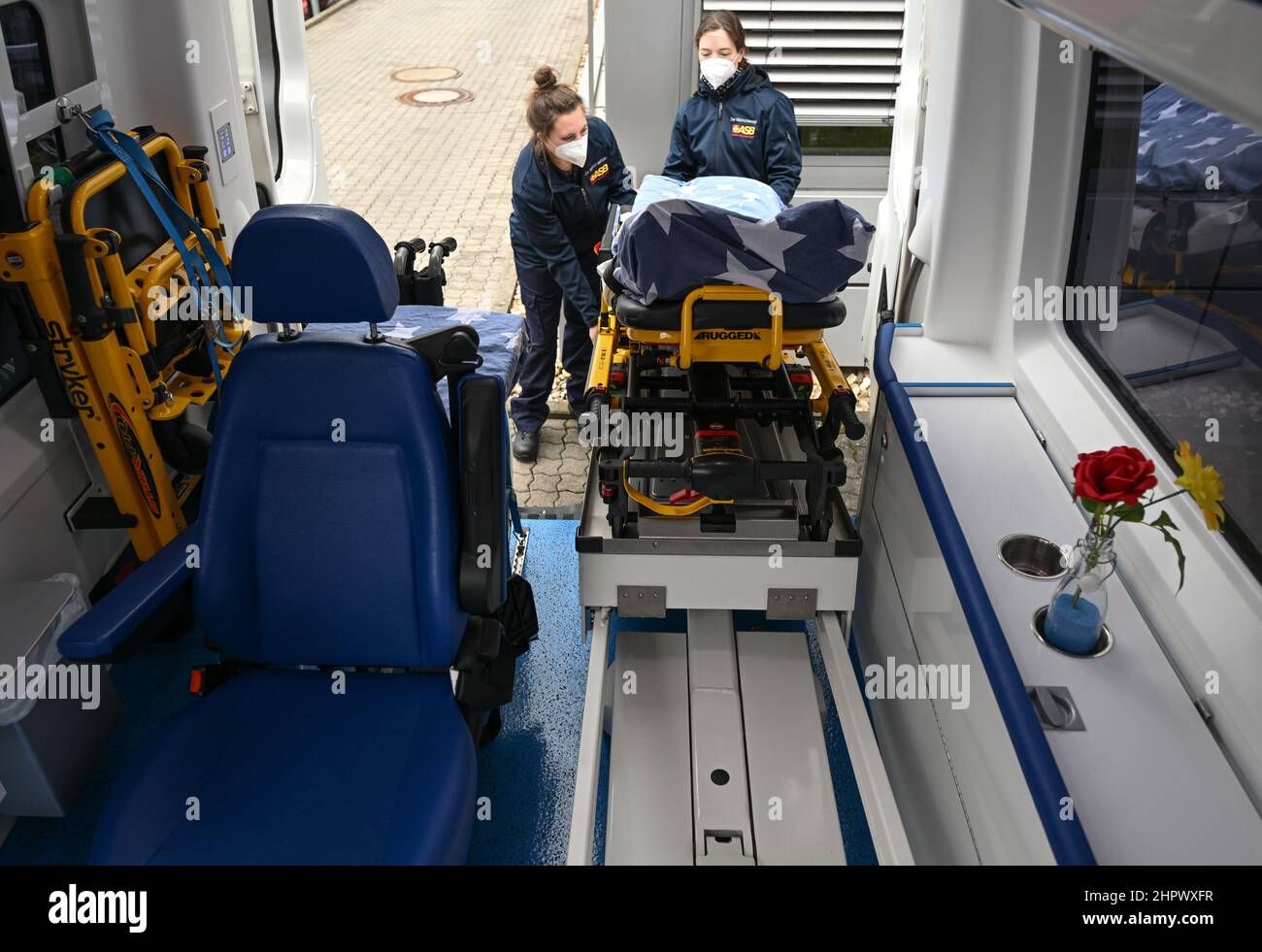 PRODUCTION - 22 February 2022, Hessen, Frankfurt/Main: Levana Clasen (l) and Michaela Loos, project coordinators at ASB, extended the special stretcher of the Wünschewagen, a medically equipped vehicle of the Arbeiter-Samariter-Bund (ASB). For five years, the ASB's Wünschewagen Rhein-Main has been driving seriously ill patients to their places of longing. The 'Wünschewagen' are on the road in all German states. The project was launched in 2014, and since then the volunteer supporters have made more than 2,000 wishes come true across Germany. The campaigns are financed exclusively by donations. Stock Photo