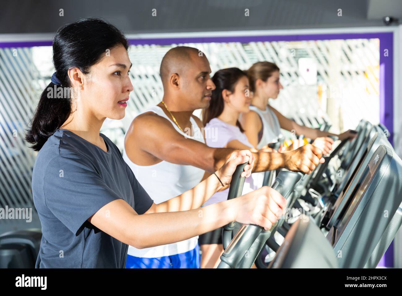 People having running elliptical trainer class in club Stock Photo Alamy