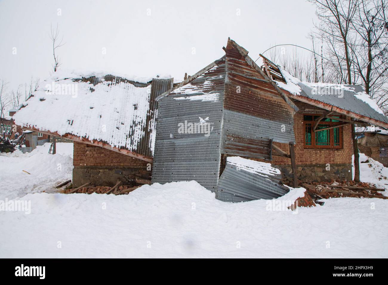 Budgam, India. 22nd Feb, 2022. A residential house seen damaged in Bugam Chadoora area. Kashmir valley received heavy snowfall, leading to the closure of roads in far-flung areas besides the delay of several flights operating from the Srinagar airport. The local train services have also been suspended. Credit: SOPA Images Limited/Alamy Live News Stock Photo