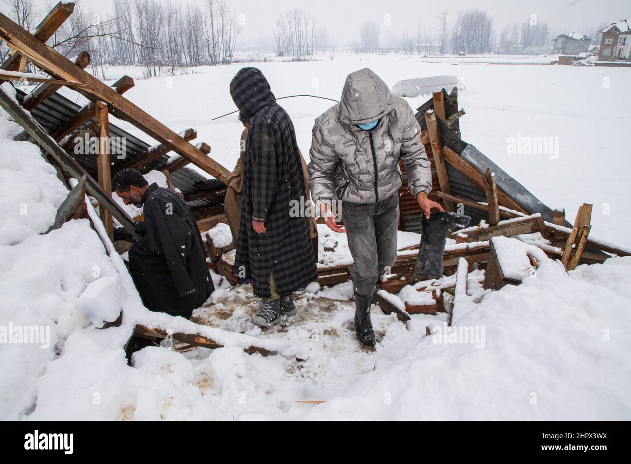 Budgam, India. 22nd Feb, 2022. People inspect a damaged house at Bugam Chadoora village. Kashmir valley received heavy snowfall, leading to the closure of roads in far-flung areas besides the delay of several flights operating from the Srinagar airport. The local train services have also been suspended. (Photo by Faisal Bashir/SOPA Images/Sipa USA) Credit: Sipa USA/Alamy Live News Stock Photo