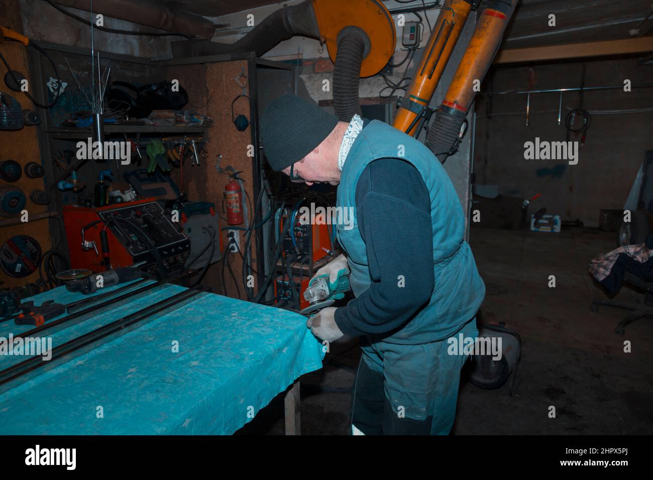 A worker using a grinder processes a metal part Stock Photo Alamy
