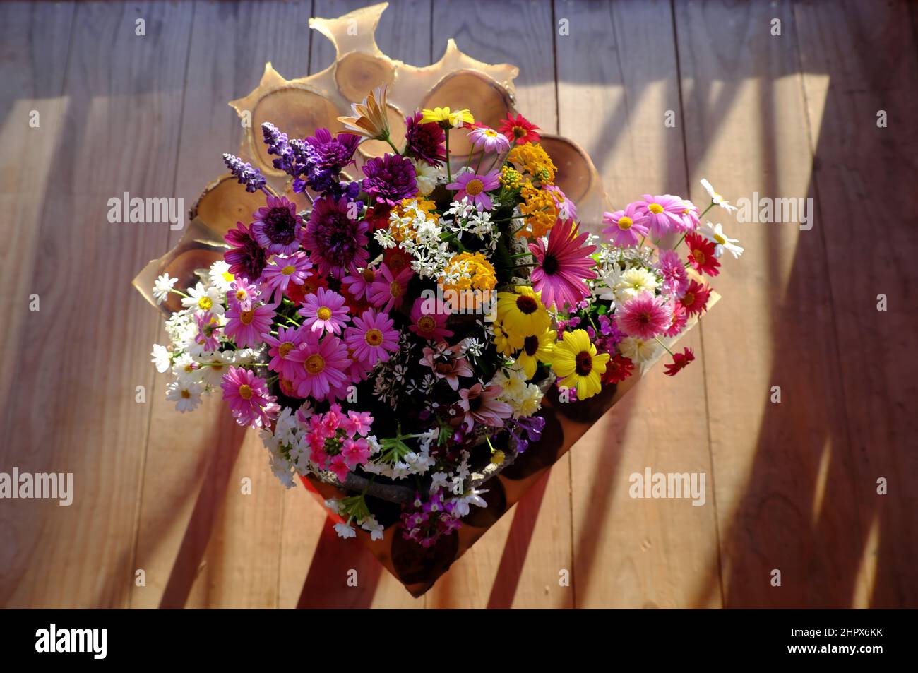 Beautiful colorful flower vase with variety daisy blossom on wooden window frame of house to decor home in springtime Stock Photo