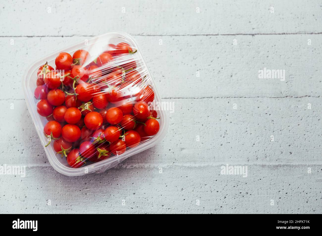 Using food packaging film for natural and organic cherry tomatoes storage in fridge. Top view