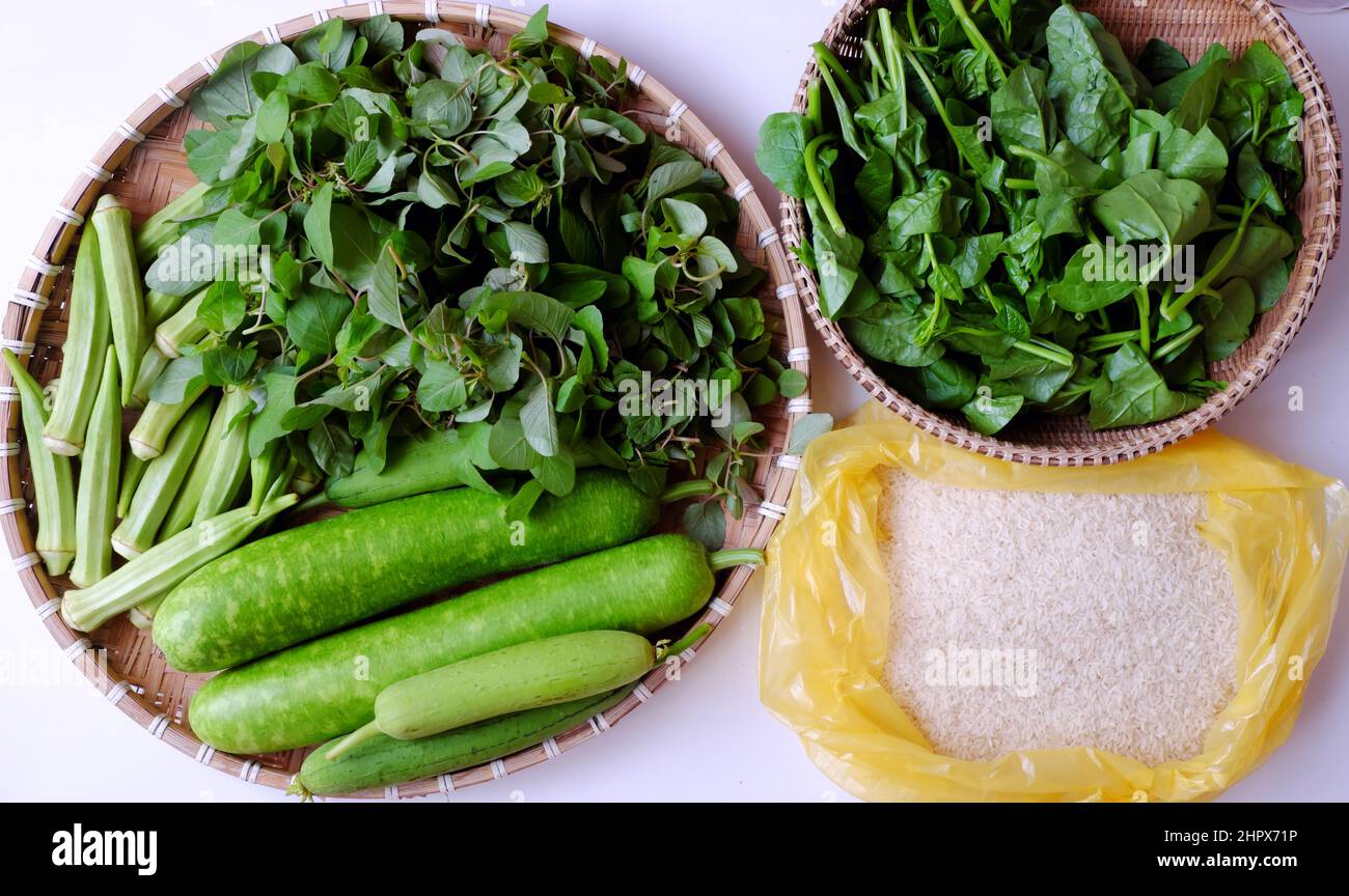 Green vegetables just harvest from city garden on rooftop house at Ho chi Minh city, melon fruit, calabash, okra, spinach on basket on white backgroun Stock Photo