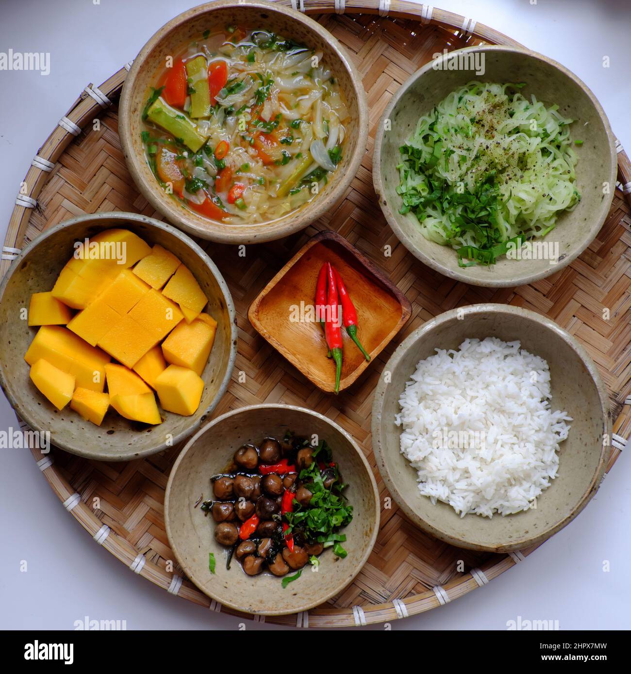 Vietnamese vegan daily family meal for lunch, tray of rice dish with fried chayote, sour soup, straw mushrooms cook with sauce, vegetarian meal Stock Photo