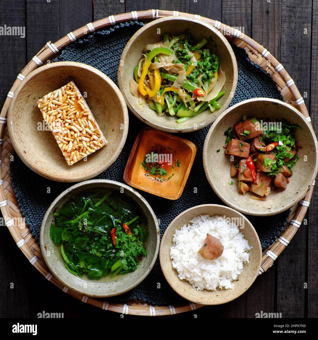 Top view tray of Vietnamese vegan food ready to eat, rice bowl, fried bell pepper, young jackfruit cook with sauce, vegetable spinach soup, non meat d Stock Photo