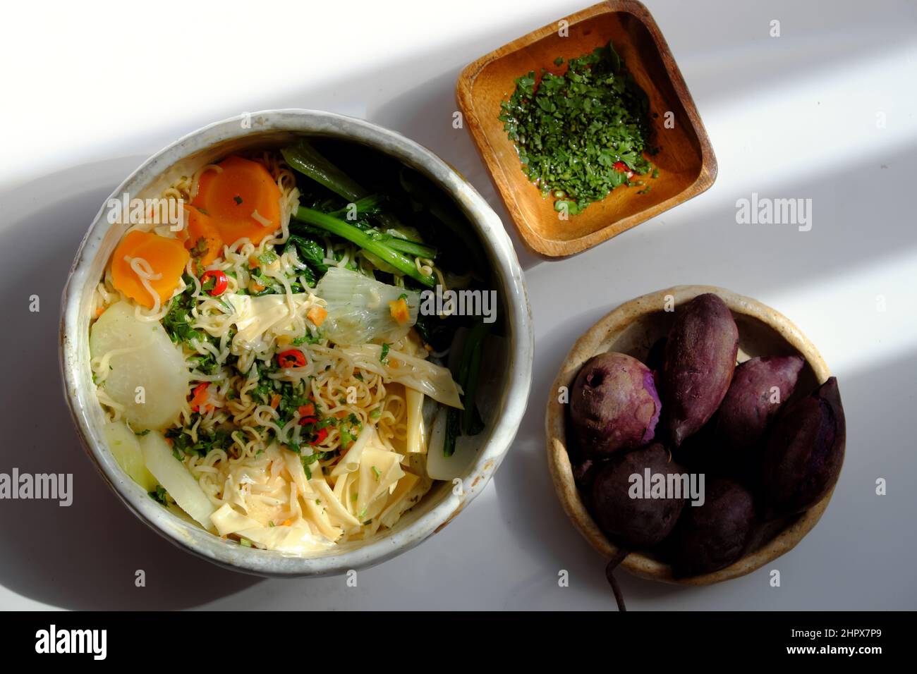 Vietnamese vegan meal for quick breakfast, instant noodle cook with mustard leaf, carrot, turnip, tofu skin, bowl of noodles soup on white background Stock Photo