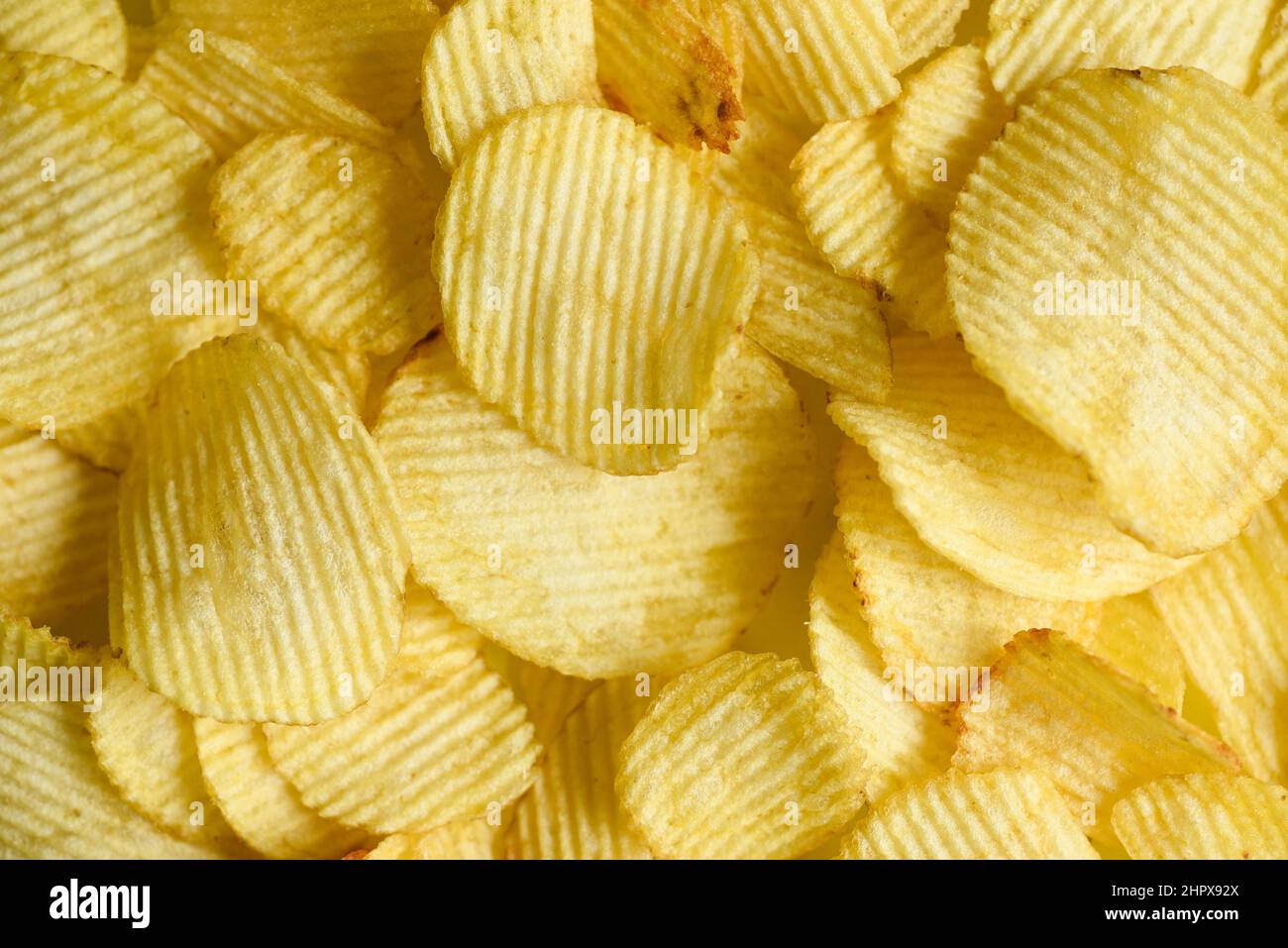 Potato chips texture background, Corrugated crispy potato chips snack - top view Stock Photo