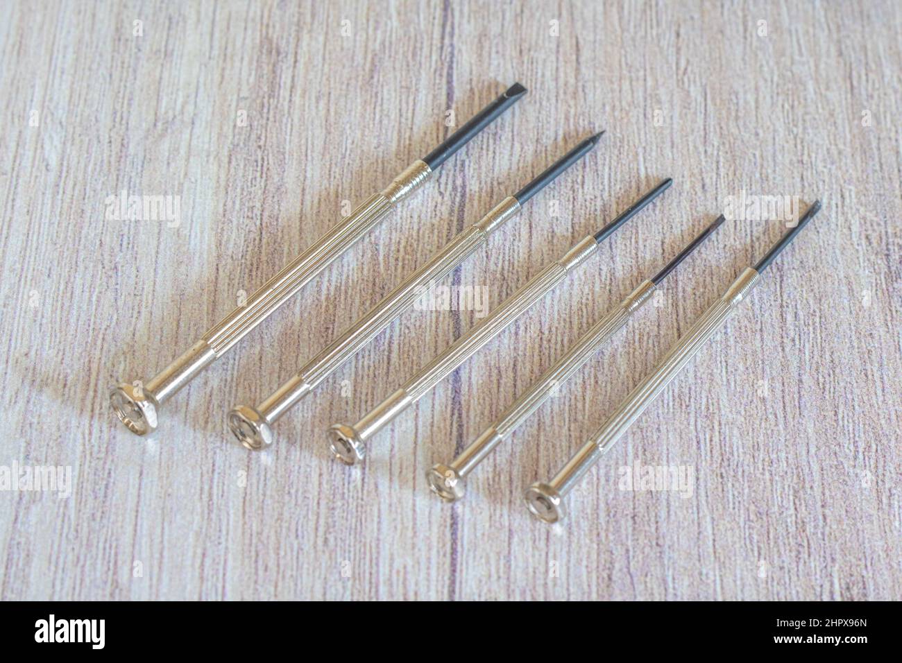 Different mini for delicate work on smallest screws in electronics and on wooden background Stock Photo