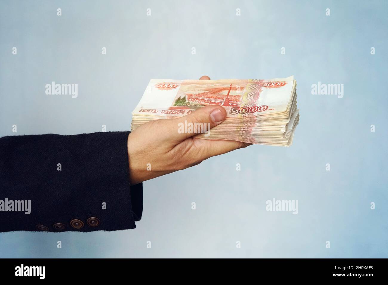 A man holds rubles in his hand, a businessman holds money in his hand. Stock Photo
