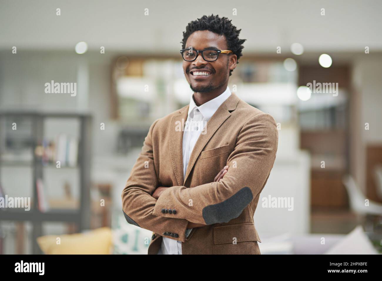 Confident and approachable African-American businessman sits at his desk in  a modern office, using a laptop. Concept of strategic thinking in a  professional business atmosphere Stock Photo - Alamy, image size:1300x957