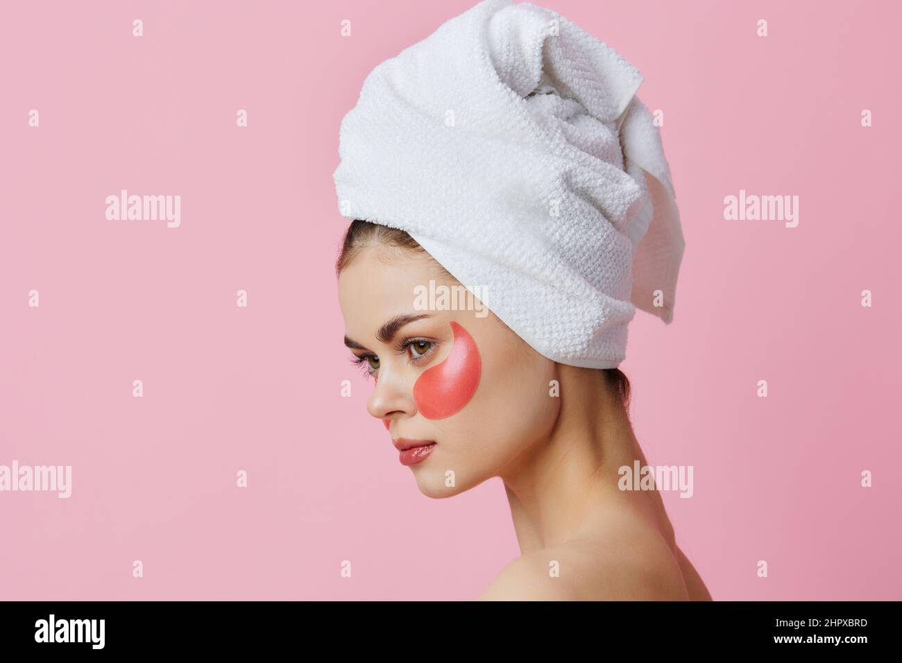 young-woman-pink-patches-on-the-face-with-a-towel-on-the-head-isolated