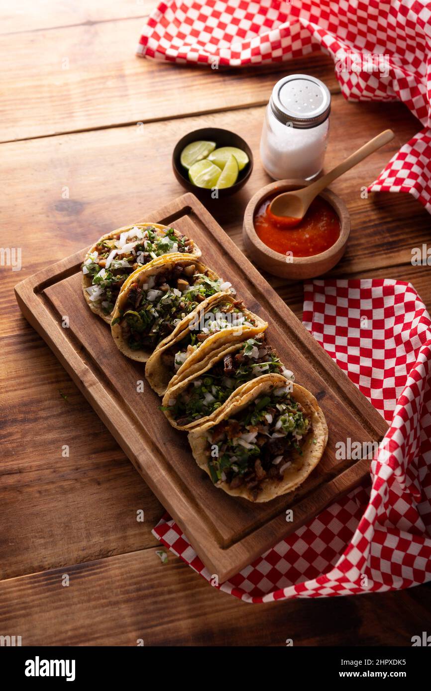Tacos de Suadero. Fried meat in a corn tortilla. Street food from CDMX, Mexico, traditionally accompanied with cilantro, onion and spicy red sauce Stock Photo