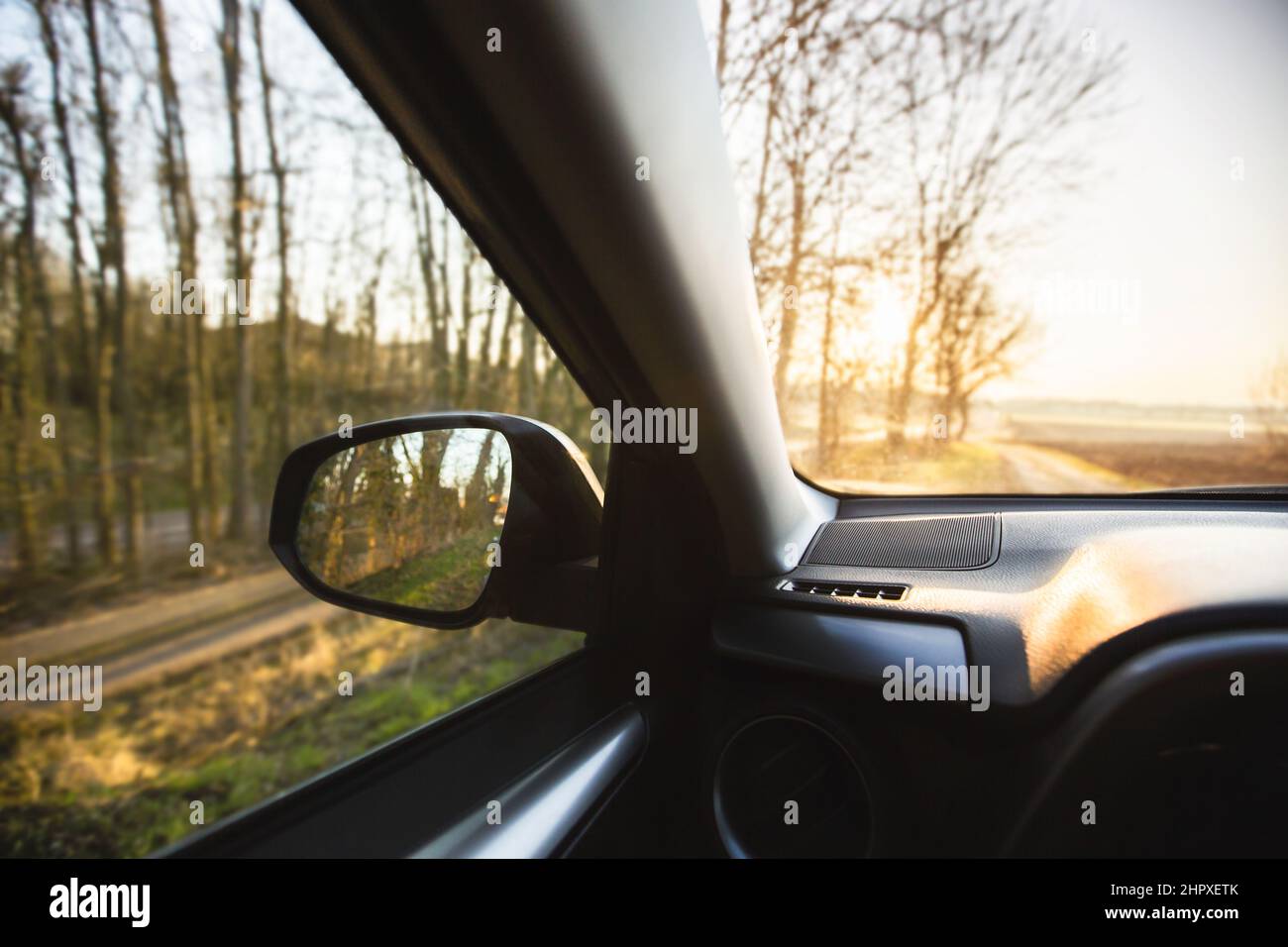 Car interior at sunrise on a forest road. Traveling with car concept . Car insurance concept Stock Photo