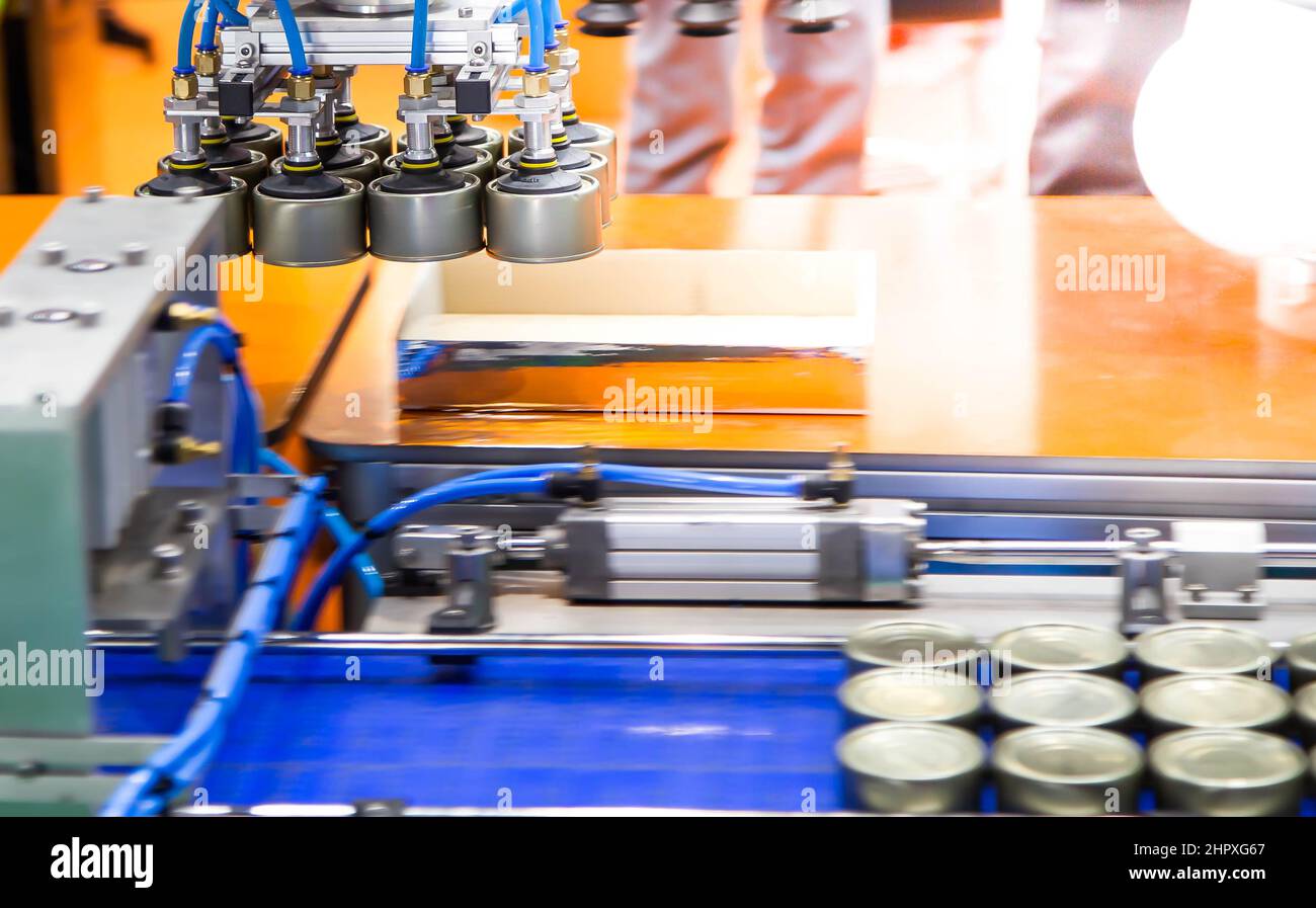 Production line of automation robot handling food can to conveyor in