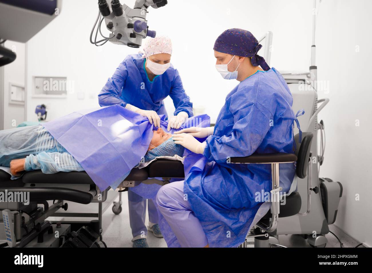 A doctor operating his patient with the help of a head nurse Stock ...