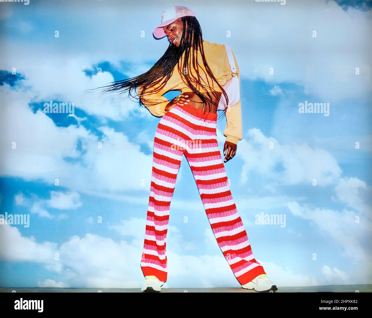 Fashion poster featuring a black female modelling trendy and youthful colorful casual outdoor clothing Stock Photo