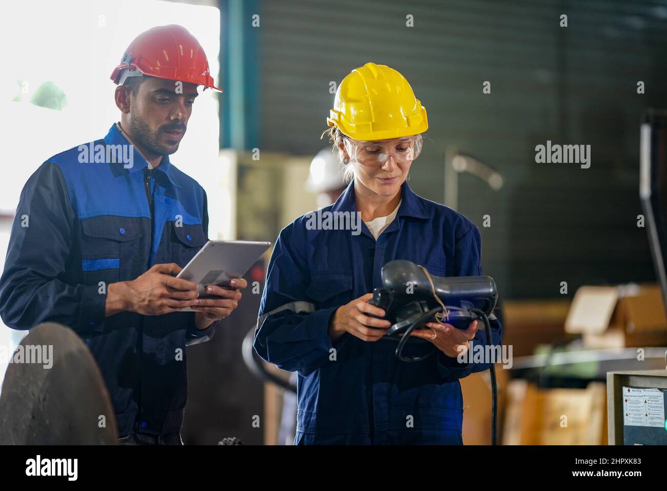 engineer checking control panel and teaching new Automatics robot arm and operating control machine in factory. Stock Photo