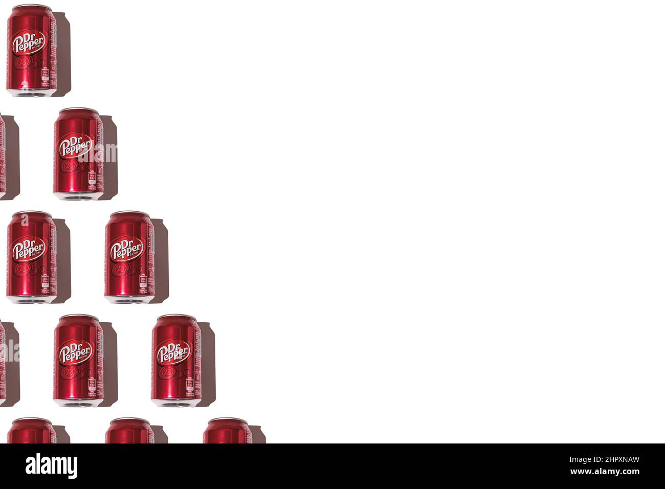 Dr. Pepper cans pattern on the left side, with hard shadow on white background. Stock Photo