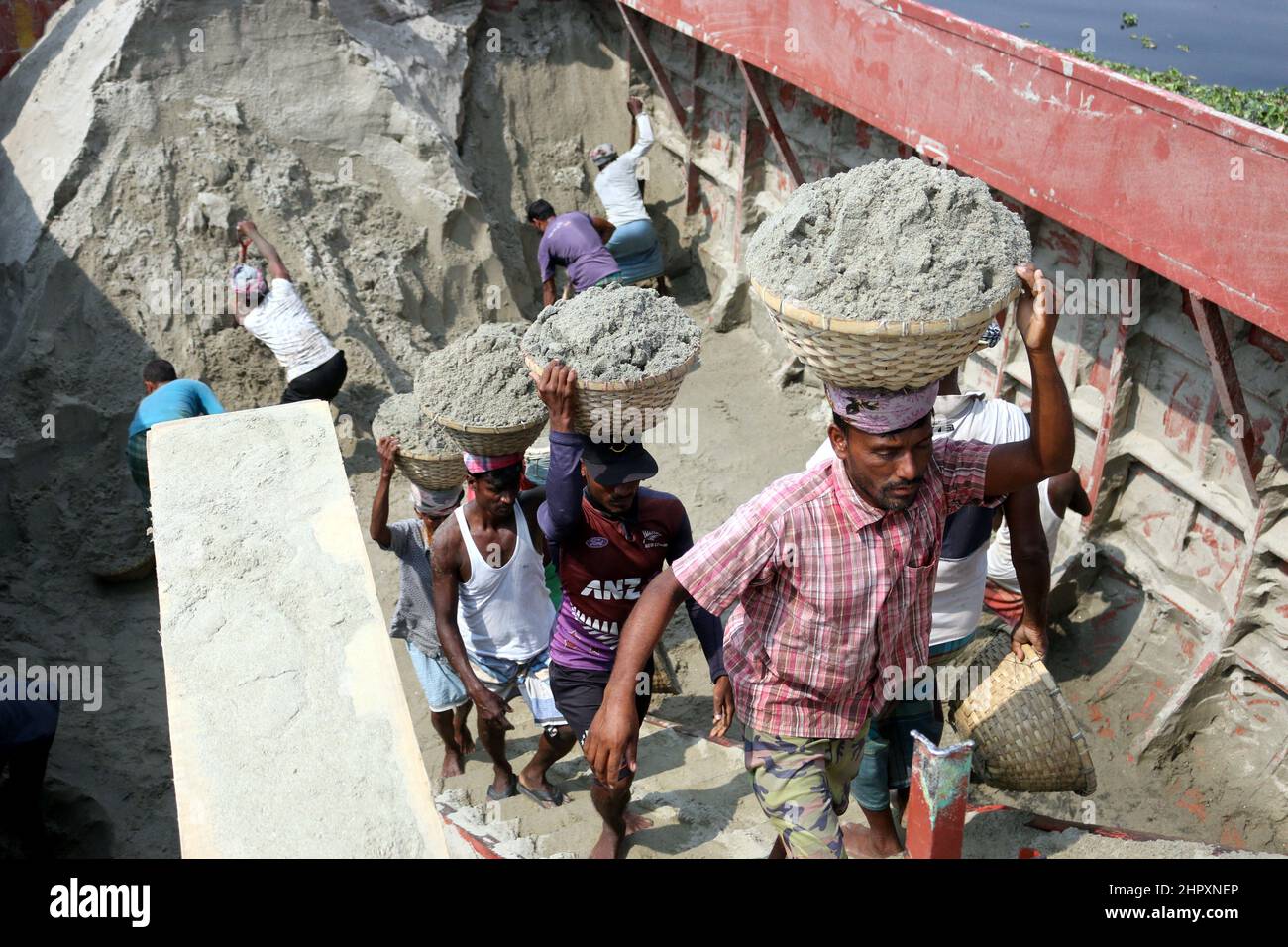 Labor load-unloading work on the banks of polluted river Shitalakshya ...