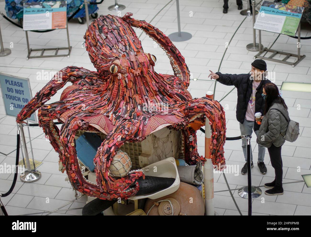 Burnaby, Canada. 23rd Feb, 2022. People look at an octopus art sculpture made from plastic marine debris during the 'Washed Ashore' exhibition at Metrotown mall in Burnaby, British Columbia, Canada, Feb. 23, 2022. The 'Washed Ashore' art sculpture exhibition came to Western Canada for the first time featuring 9 giant marine wildlife sculptures made entirely from plastic marine debris that has been collected from the Pacific Ocean. The exhibition runs from Feb. 23 to April 30. Credit: Liang Sen/Xinhua/Alamy Live News Stock Photo