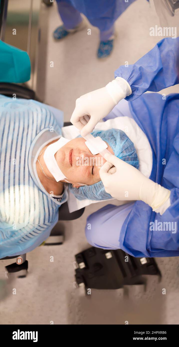 Doctor putting an eye patch on his patient after a successful cataract operation Stock Photo