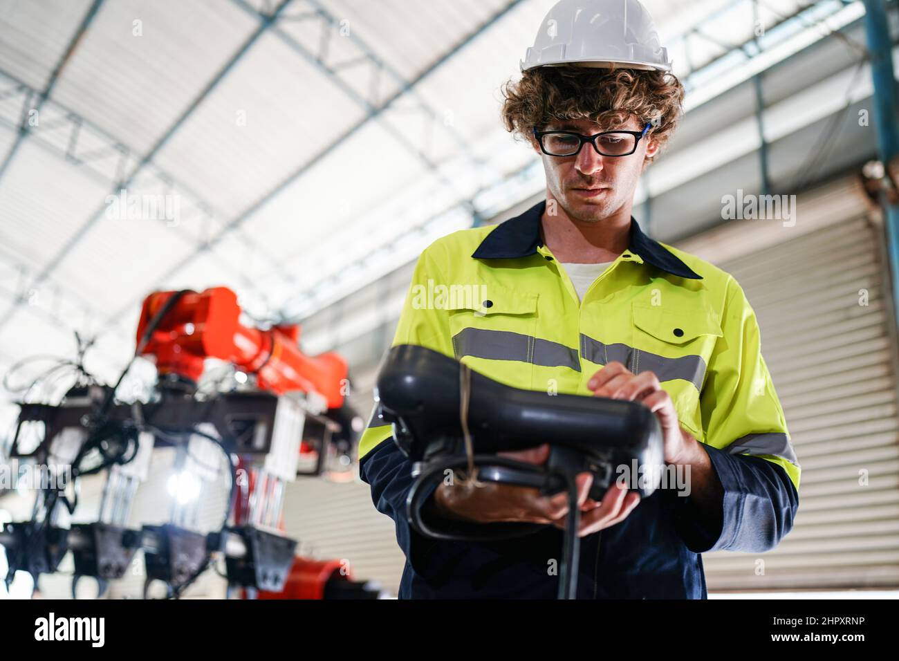engineer checking control panel and teaching new Automatics robot arm and operating control machine in factory. Stock Photo