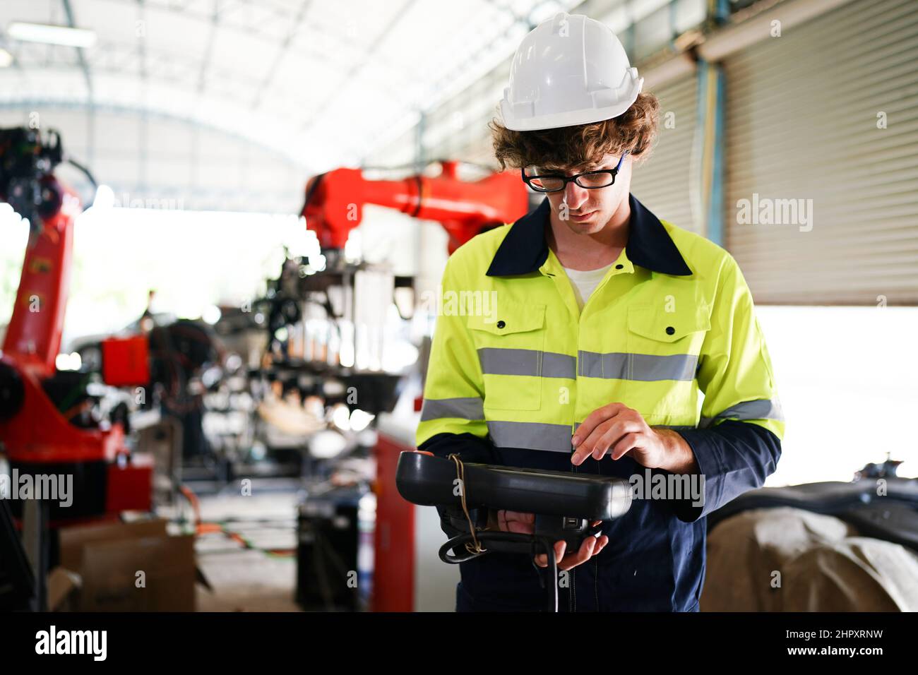 engineer checking control panel and teaching new Automatics robot arm and operating control machine in factory. Stock Photo