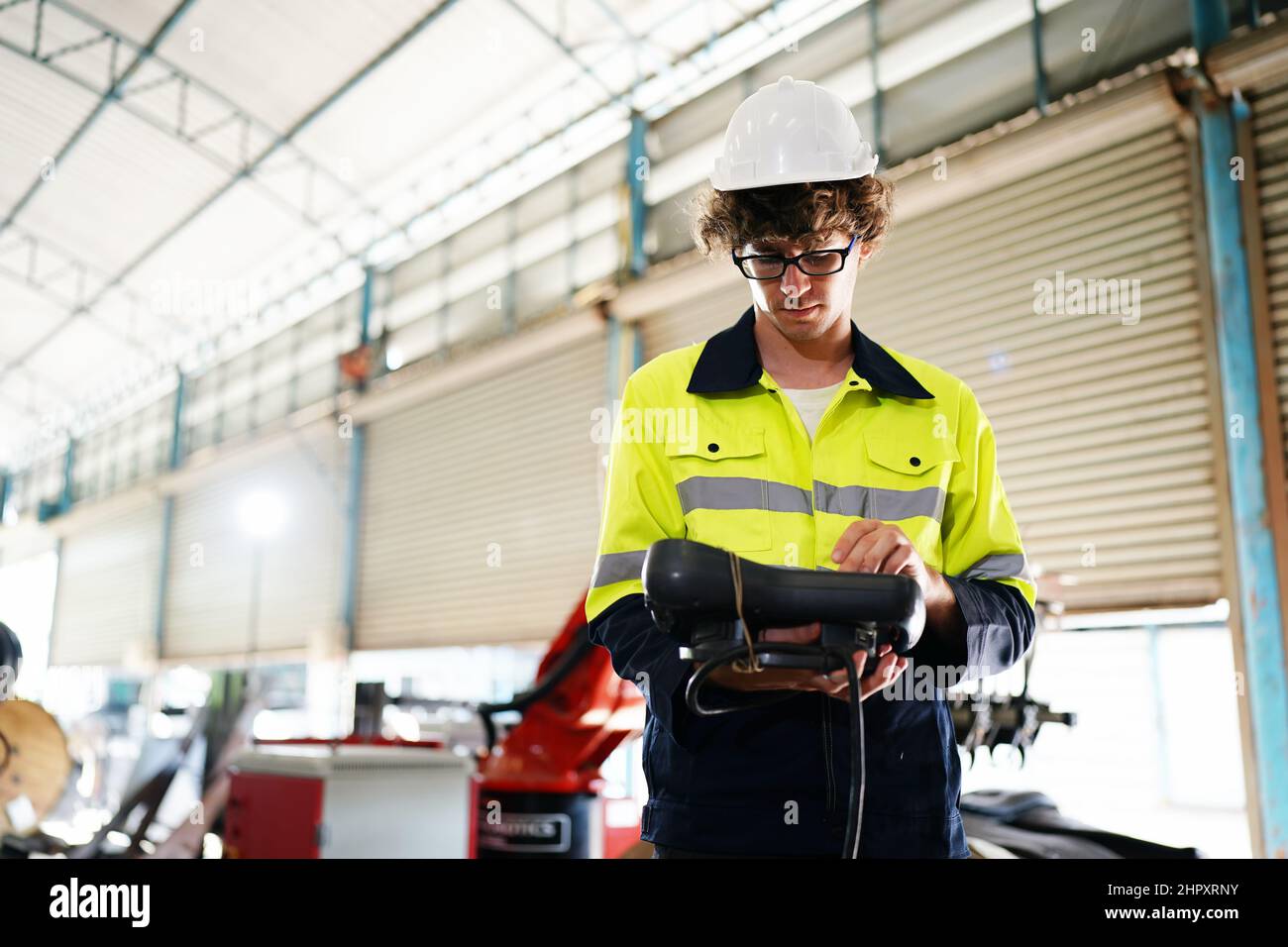 engineer checking control panel and teaching new Automatics robot arm and operating control machine in factory. Stock Photo