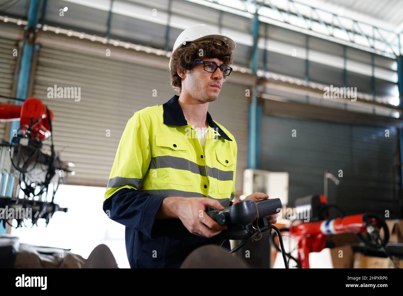 engineer checking control panel and teaching new Automatics robot arm and operating control machine in factory. Stock Photo