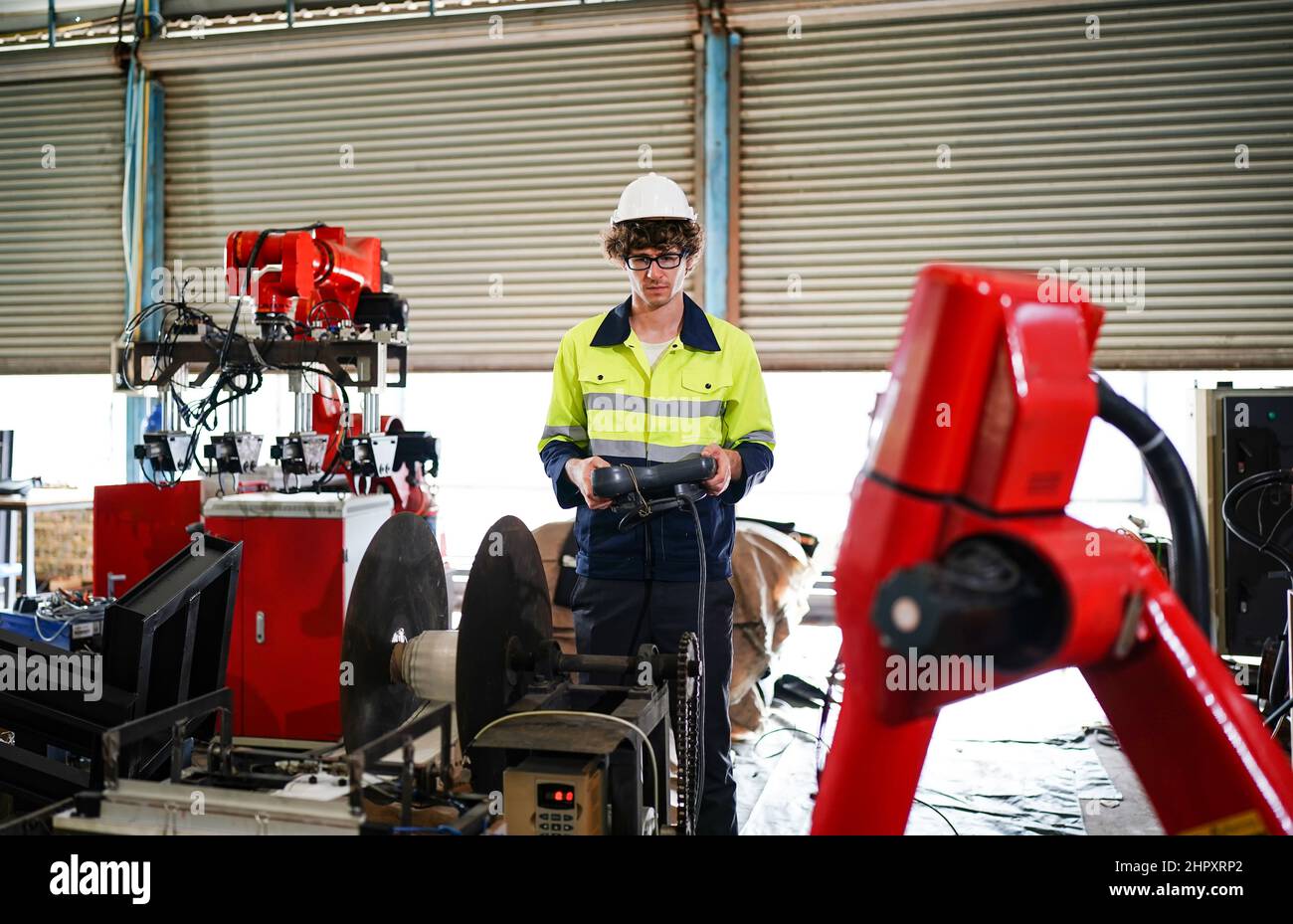 engineer checking control panel and teaching new Automatics robot arm and operating control machine in factory. Stock Photo