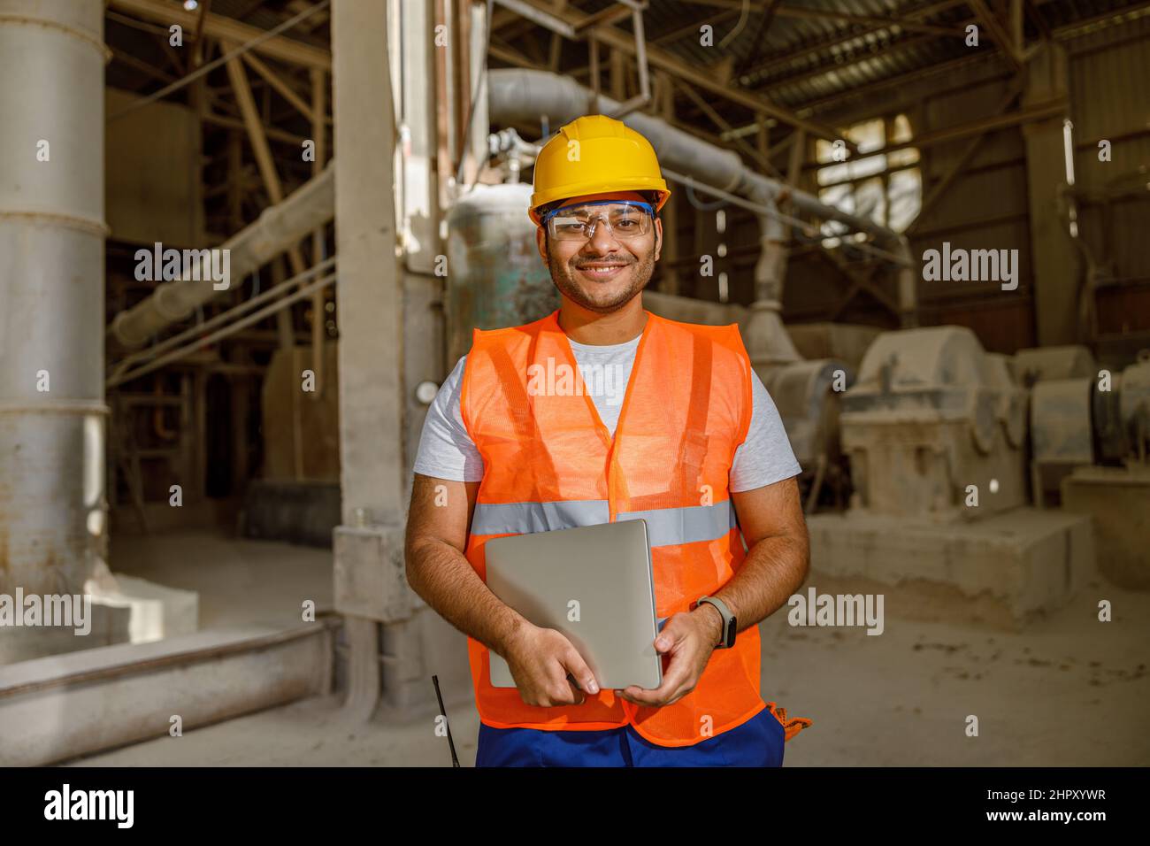 Smiling young construction engineer working in plant Stock Photo
