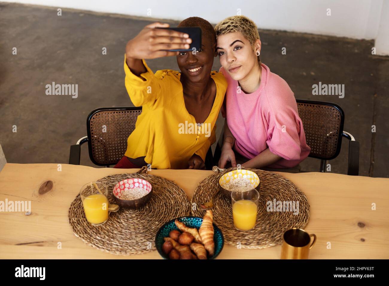 Happy multiethnic couple taking a selfie while having dinner Stock Photo