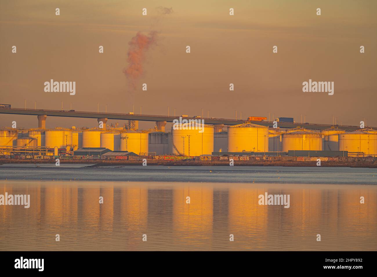 Sunrise hitting oil storage tanks at West Thurrock, Essex. Stock Photo