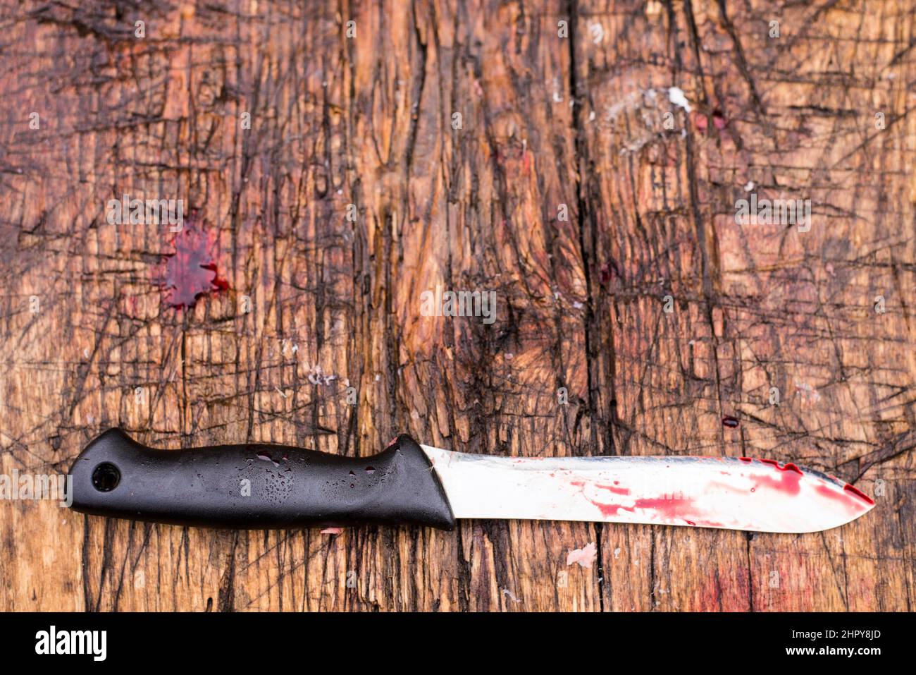 Bloody slaughter knife on a hard wooden cut chopping board. Home slaughter. Stock Photo